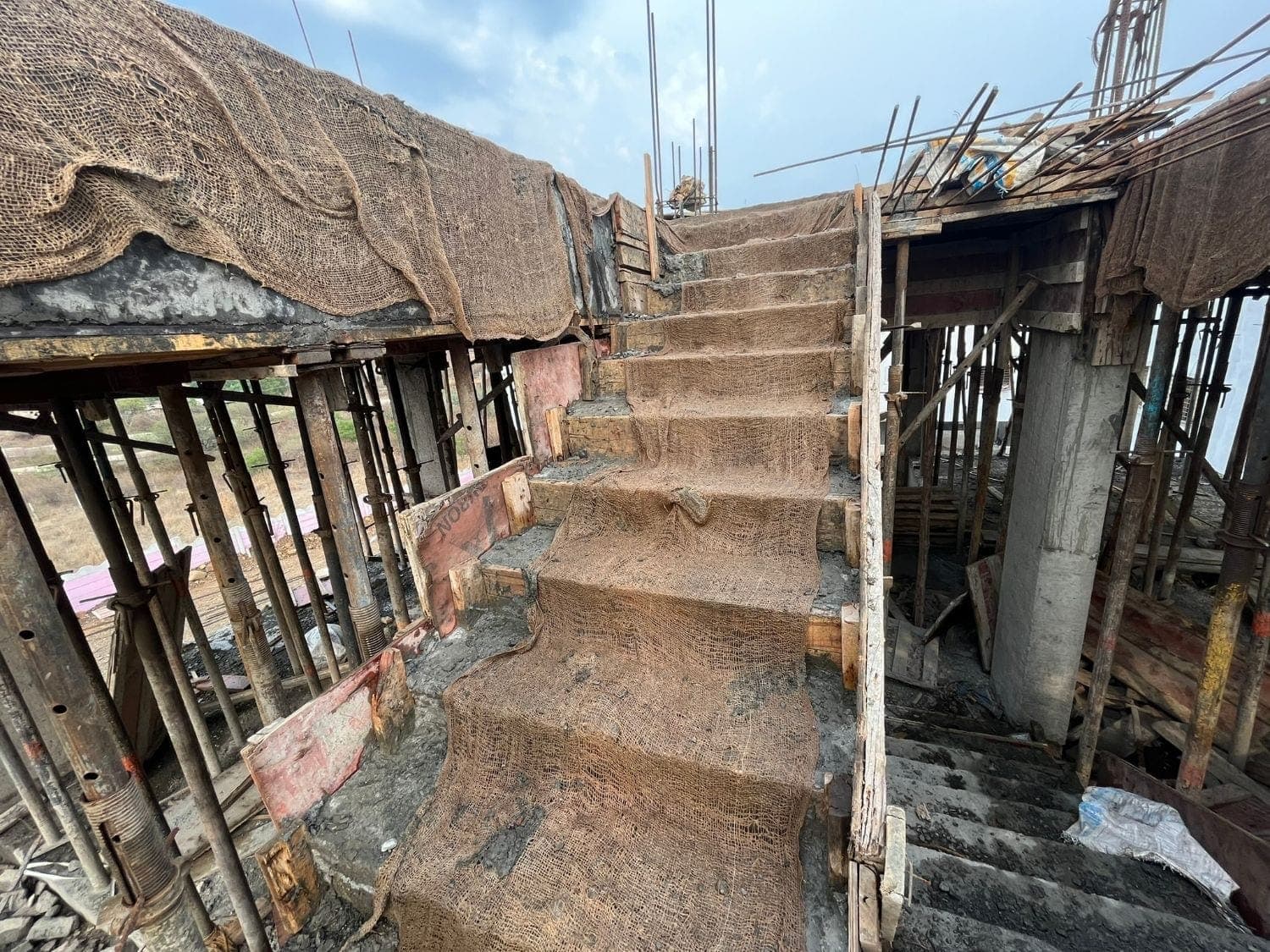 Staircase curing under hessian — Shinde House, Charholi, Pune